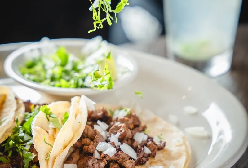 Street tacos with salsa, lime and cilantro at El Jinete